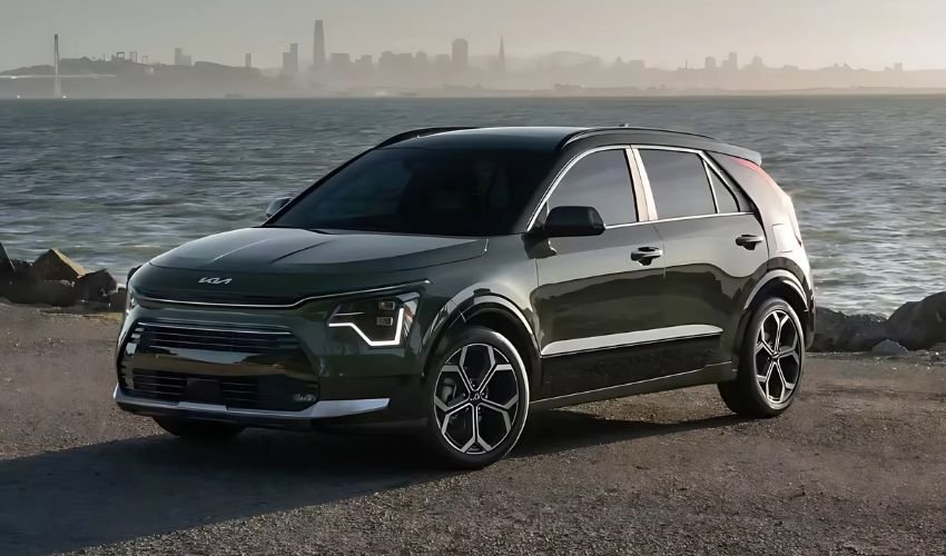 A dark green Kia Niro parked on a waterfront.