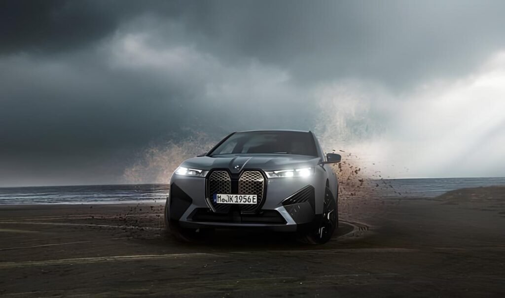 A powerful electric SUV navigates a sandy beach under a dramatic stormy sky