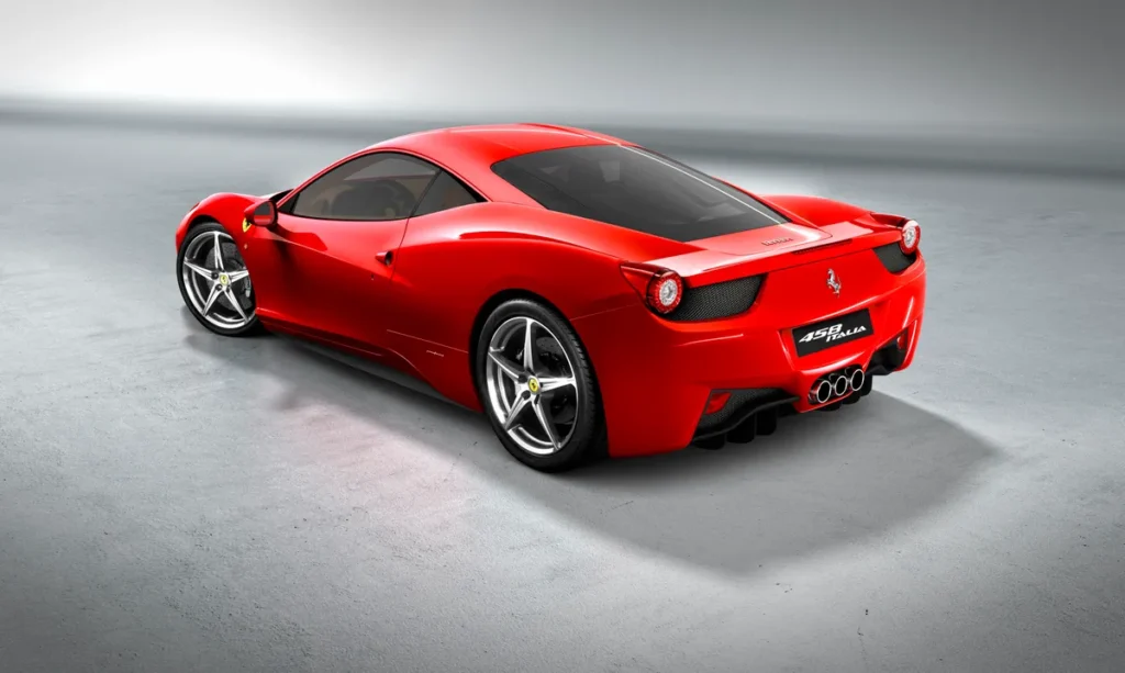 A stunning red Ferrari 458 Italia is showcased in a studio setting. 