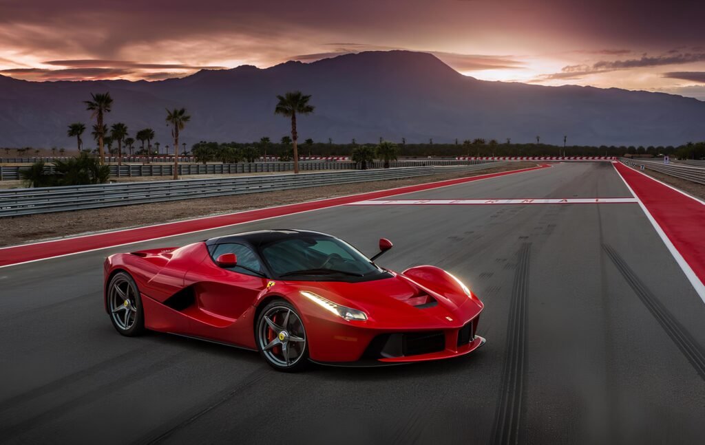 A powerful red Ferrari LaFerrari ready to race on a scenic track at sunset.