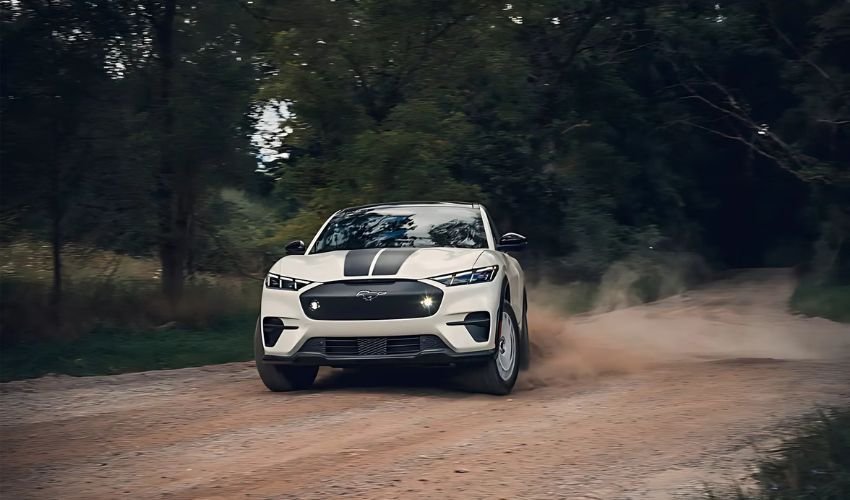 A white Ford Mustang Mach-E driving on a dirt road