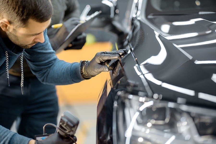 Car Service worker performing car body maintenance