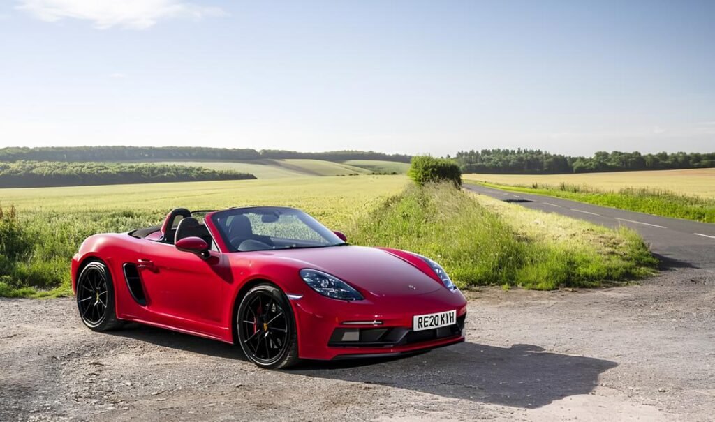 A 2021 Porsche 718 Boxster with its top down, showcasing reliable German engineering.