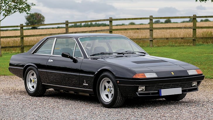 A classic black Ferrari 400 parked outdoors, showcasing a vintage driving experience