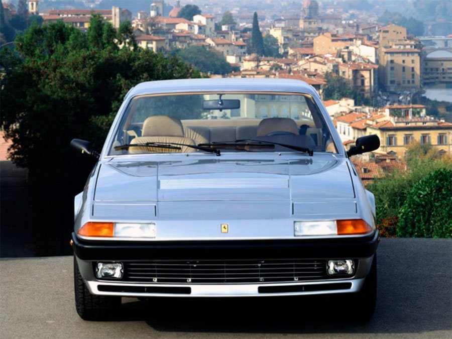 A sleek Ferrari showcasing the design evolution of sports cars, parked with an old cityscape in the background.