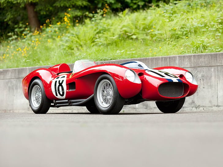 Classic Ferrari 250 Testa Rossa convertible racing car parked on pavement.