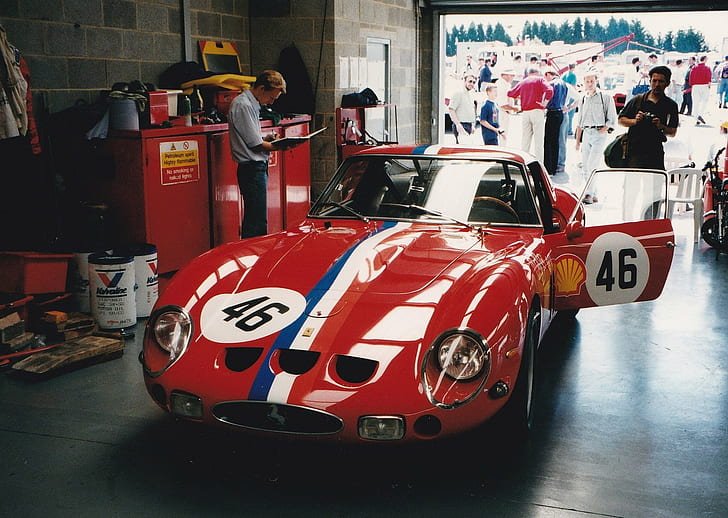 Vintage red 250 GTO with number 46 in a garage.