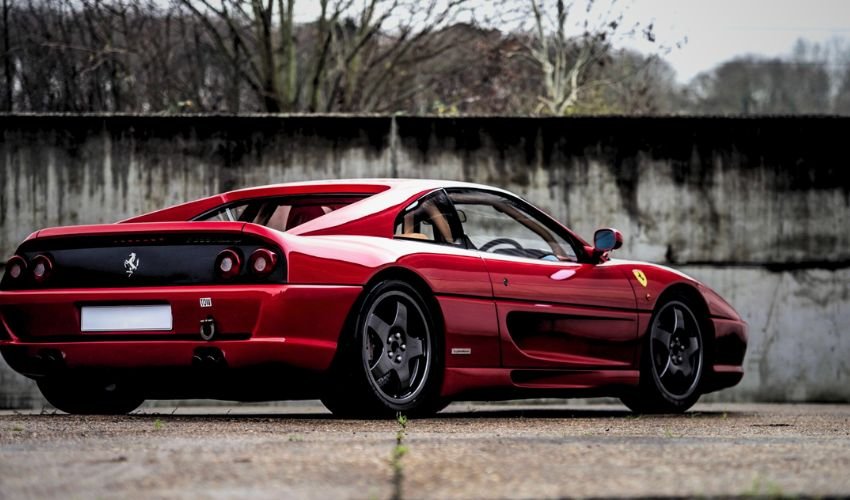 A red Ferrari F355 sports car parked outdoors.