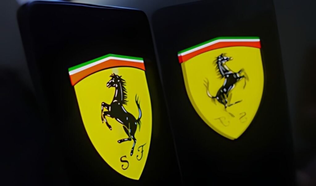 Two Ferrari emblems on a dark background, one in focus and the other blurred