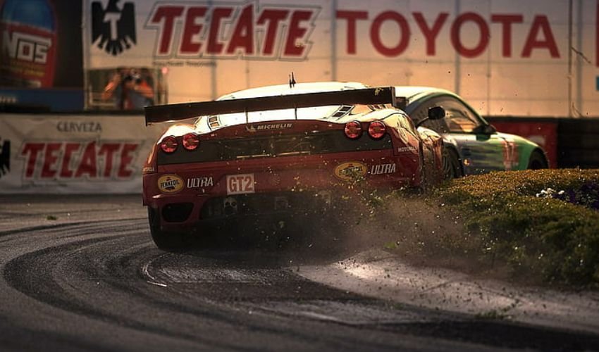 Race-modified Ferrari kicking up dirt on a track.