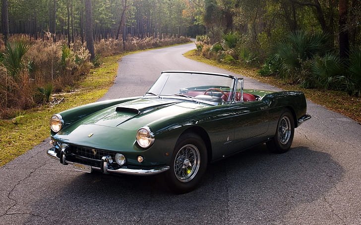 Ferrari roadster cruising along a scenic road.