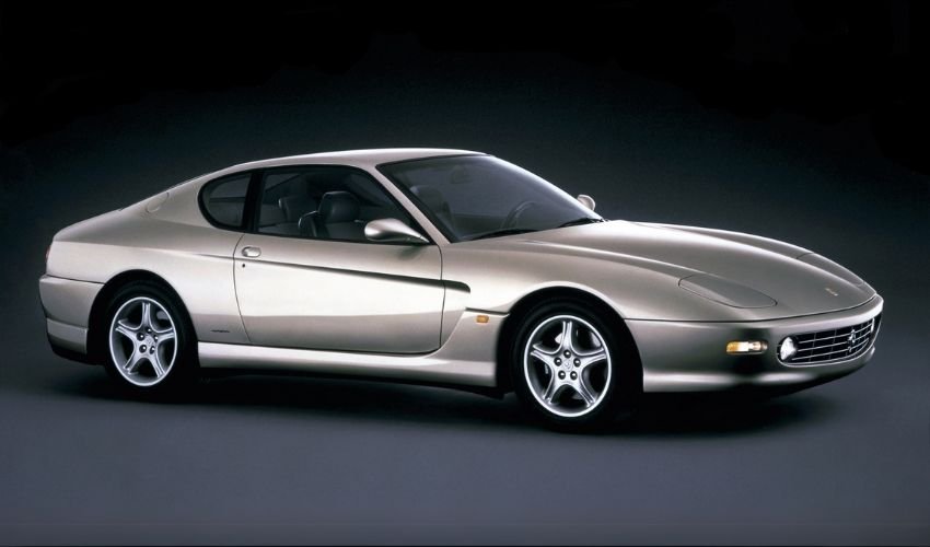 A silver Ferrari 456 GT sports car against a dark background