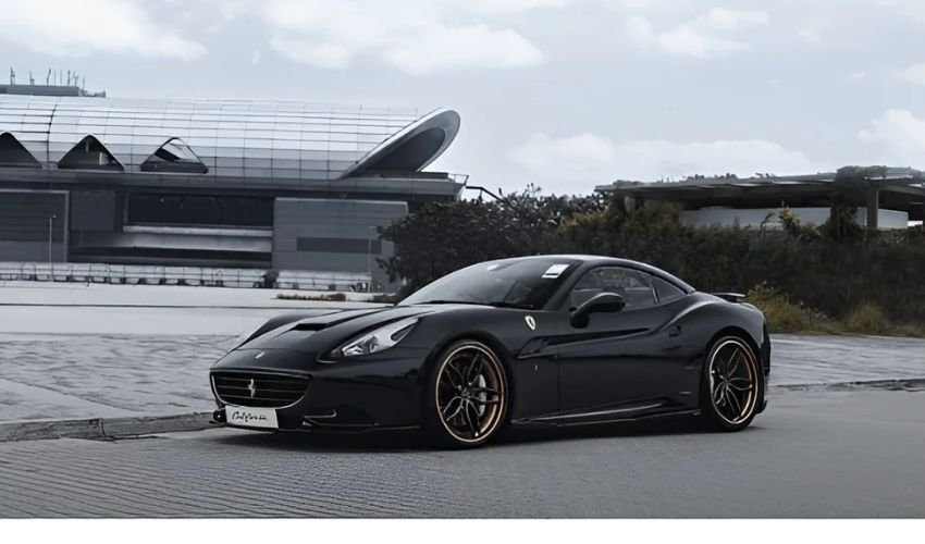 A black Ferrari California parked under overcast skies